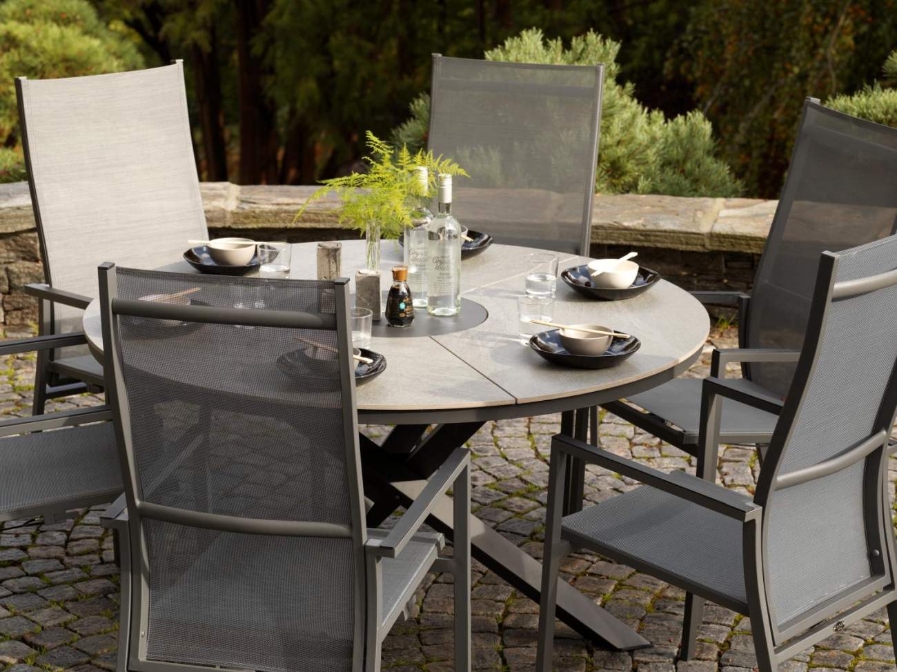 Der Gartenesstisch Kenora überzeugt mit seinem modernen Design. Gefertigt wurde die Tischplatte aus Granit und hat eine hellgraue Farbe. Das Gestell ist auch aus Metall und hat eine schwarze Farbe. Der Tisch besitzt einen Durchmesser von 137 cm.