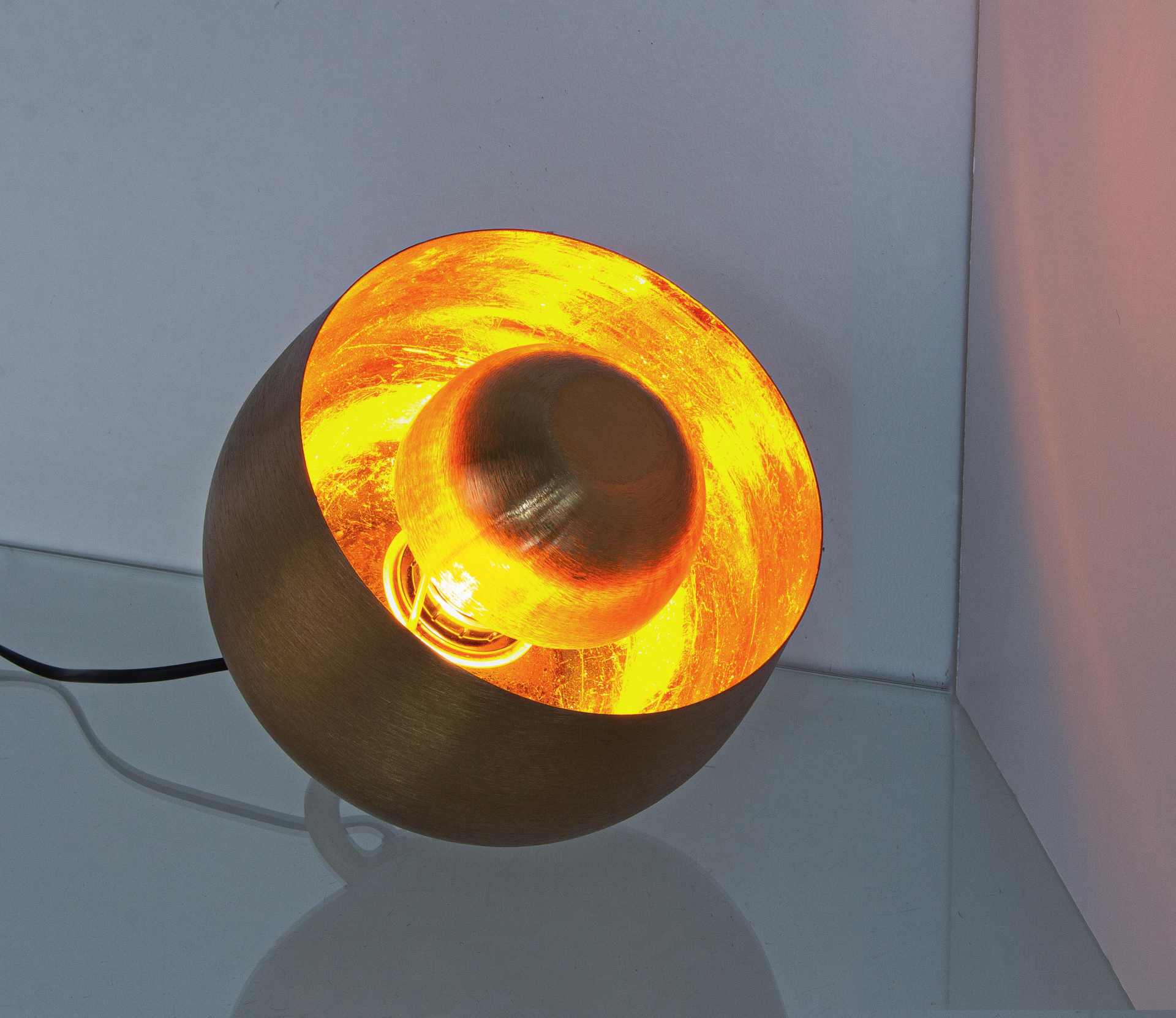Die Tischleuchte Ishan überzeugt mit ihrem modernen Design. Gefertigt wurde sie aus Metall, welches einen goldenen Farbton besitzt. Die Lampe hat eine Lichtquelle. Die Lampe besitzt eine Höhe von 22 cm.