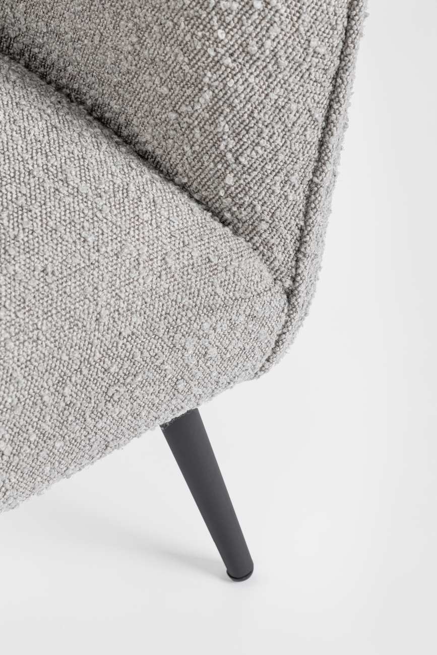 Der Sessel Avril überzeugt mit seinem modernen Stil. Gefertigt wurde er aus Bouclè-Stoff, welcher einen grauen Farbton besitzt. Das Gestell ist aus Metall und hat eine schwarze Farbe. Der Sessel verfügt über eine Armlehne.