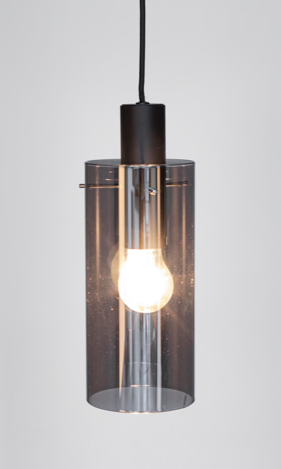 Die Hängeleuchte Aglow überzeugt mit ihrem modernen Design. Gefertigt wurde sie aus Metall, welches einen schwarzen Farbton besitzt. Der Lampenschirm ist aus Glas und ist abgedunkelt. Die Lampe besitzt eine Höhe von 130 cm.
