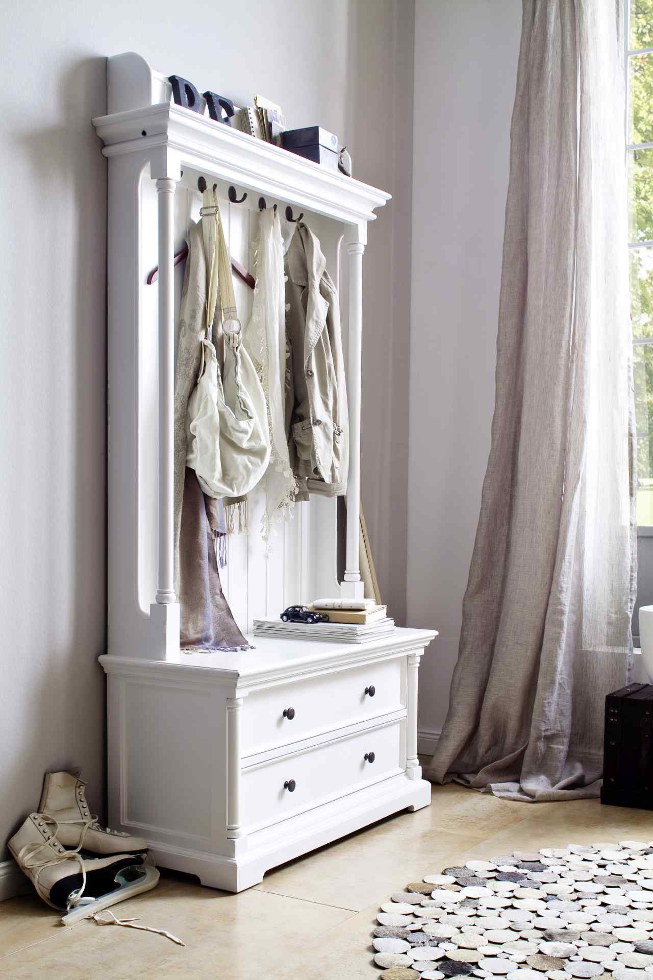 Die Garderobe Provence überzeugt mit ihrem Landhaus Stil. Gefertigt wurde sie aus Mahagoni Holz, welches einen weißen Farbton besitzt. Die Garderobe verfügt über zwei Schubladen, fünf Haken und eine Sitzbank. Die Breite beträgt 100 cm.