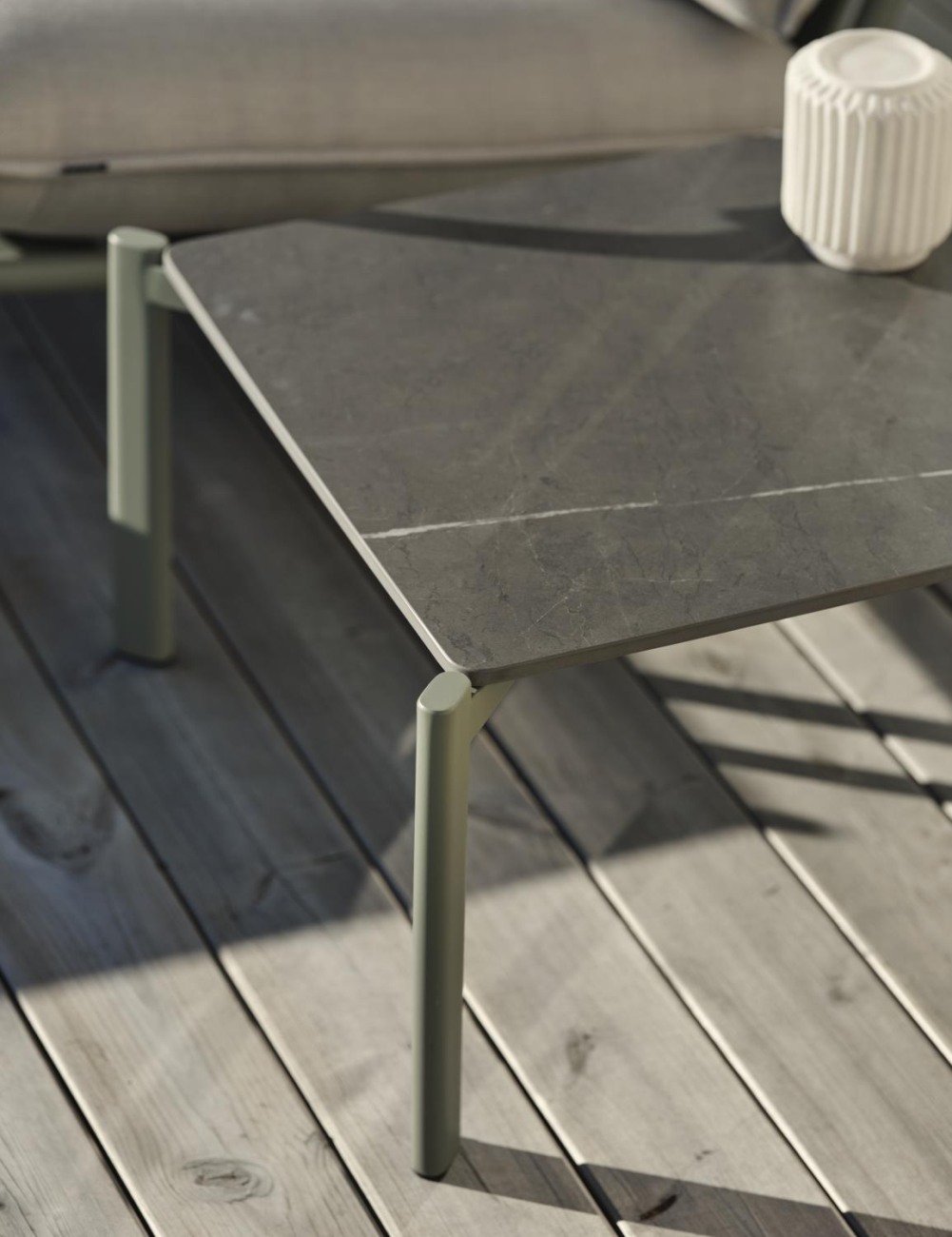 Der Gartencouchtisch Gotland überzeugt mit seinem modernen Design. Gefertigt wurde die Tischplatte aus Granit und besitzt einen grauen Farbton. Das Gestell ist auch aus Metall und hat eine grüne Farbe. Der Tisch besitzt eine Länger von 56 cm.