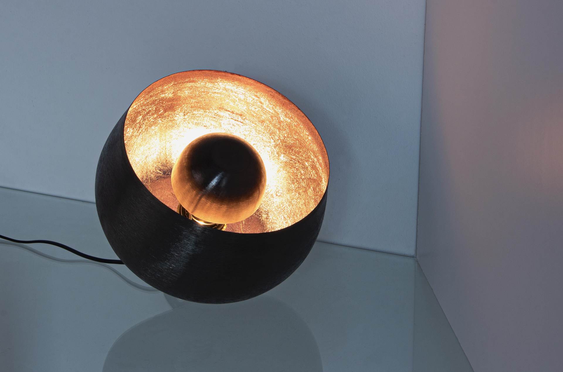 Die Tischleuchte Ishan überzeugt mit ihrem modernen Design. Gefertigt wurde sie aus Metall, welches einen schwarzen Farbton besitzt. Die Lampe hat eine Lichtquelle. Die Lampe besitzt eine Höhe von 24,5 cm.