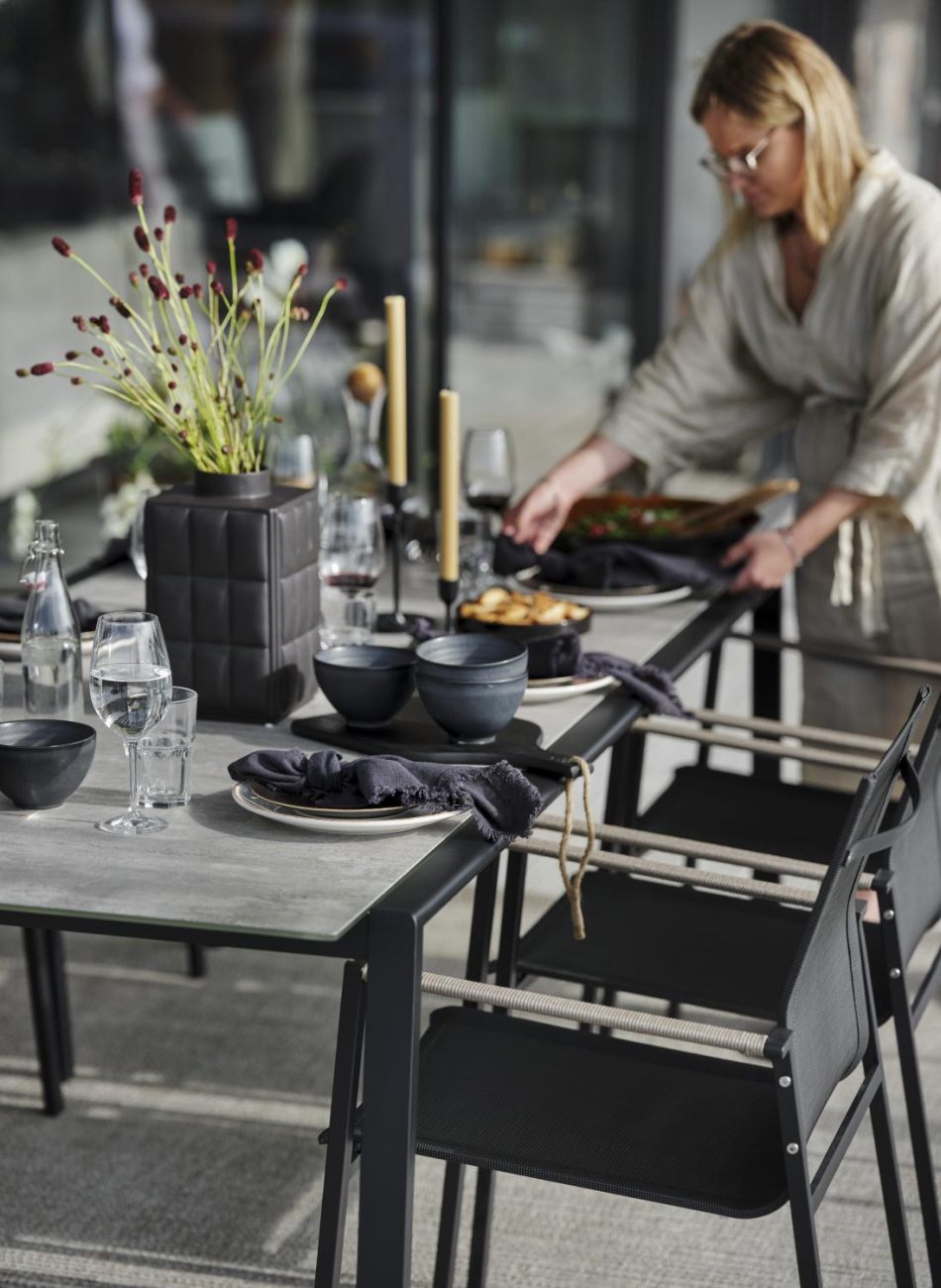 Der Gartenesstisch Lyra überzeugt mit seinem modernen Design. Gefertigt wurde die Tischplatte aus Granit und hat eine hellgraue Farbe. Das Gestell ist auch aus Metall und hat eine schwarze Farbe. Der Tisch besitzt eine Länge von 220 cm.