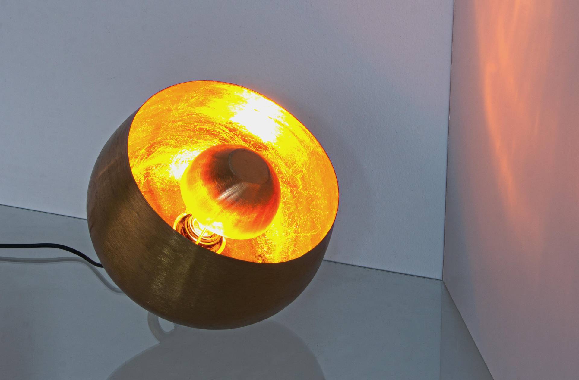 Die Tischleuchte Ishan überzeugt mit ihrem modernen Design. Gefertigt wurde sie aus Metall, welches einen goldenen Farbton besitzt. Die Lampe hat eine Lichtquelle. Die Lampe besitzt eine Höhe von 24,5 cm.