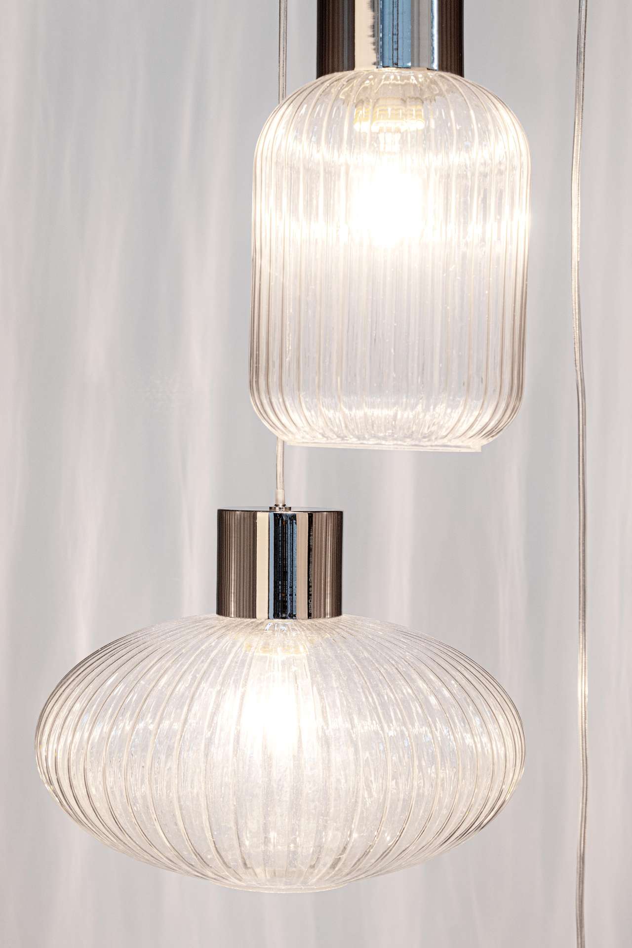 Die Hängeleuchte Showy überzeugt mit ihrem modernen Design. Gefertigt wurde sie aus Metall, welches einen silberne Farbton besitzt. Die Lampenschirme sind aus Glas und sind klar. Die Lampe besitzt eine Höhe von 150 cm.