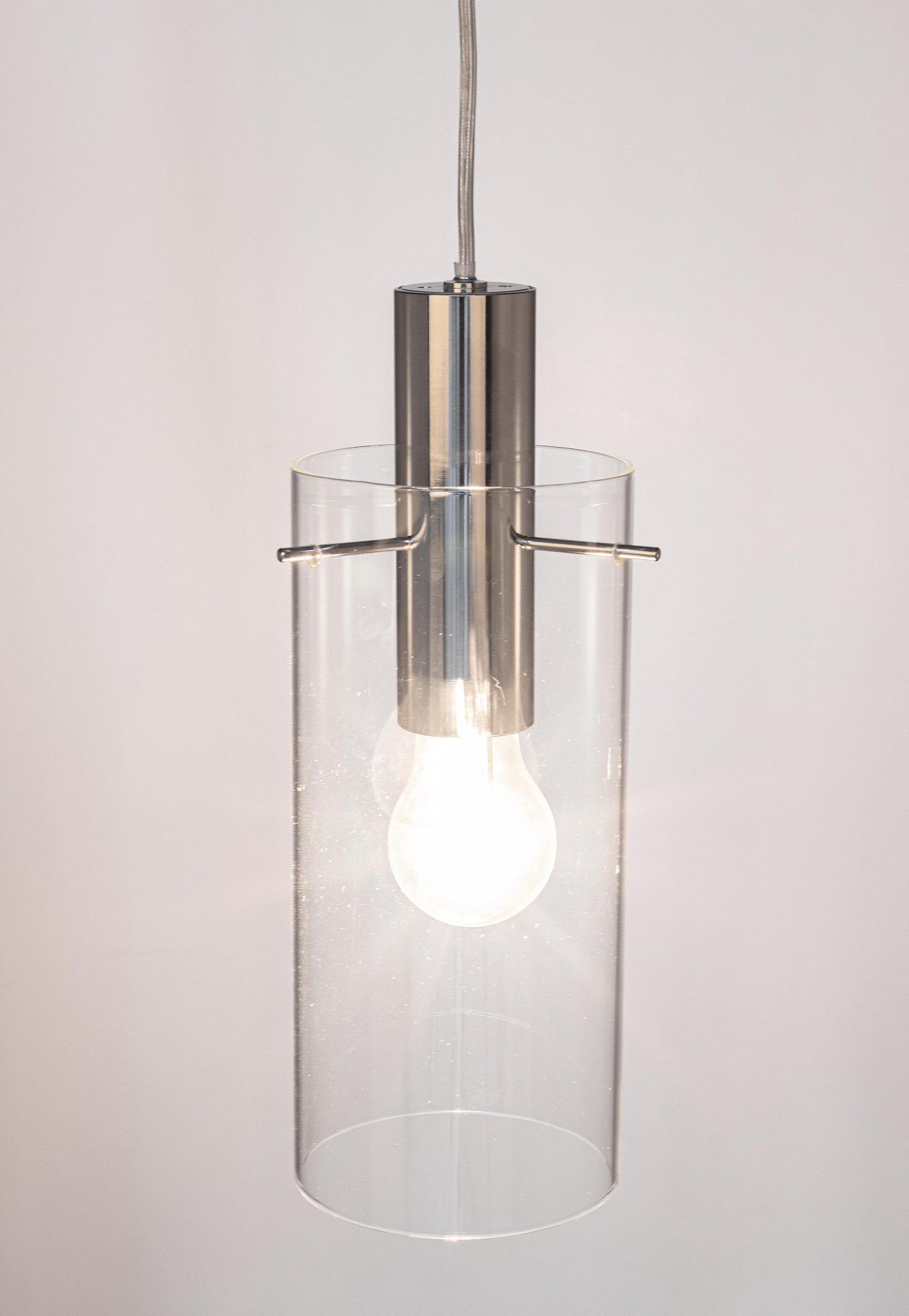 Die Hängeleuchte Aglow überzeugt mit ihrem modernen Design. Gefertigt wurde sie aus Metall, welches einen silberne Farbton besitzt. Der Lampenschirm ist aus Glas und ist klar. Die Lampe besitzt eine Höhe von 130 cm.
