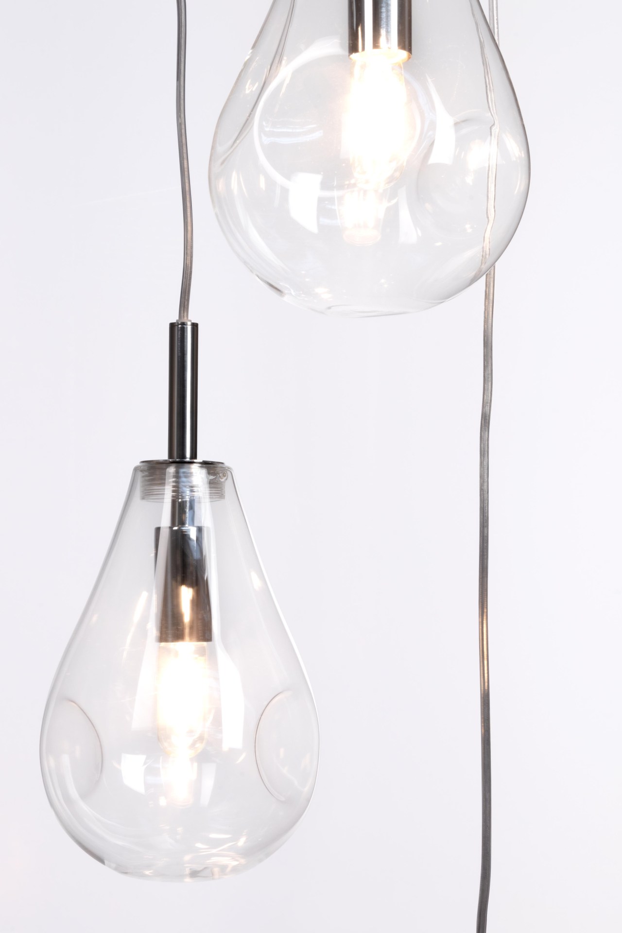 Die Hängeleuchte Refelct überzeugt mit ihrem modernen Design. Gefertigt wurde sie aus Metall, welches einen silberne Farbton besitzt. Die Lampenschirme sind aus Glas und sind klar. Die Lampe besitzt eine Höhe von 120 cm.