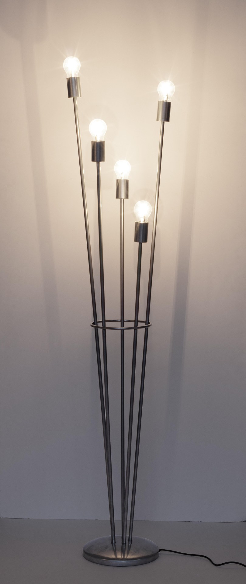 Die Stehleuchte Fiaccola überzeugt mit ihrem modernen Design. Gefertigt wurde sie aus Metall, welches einen silbernen Farbton besitzt. Die Lampenschirme ist aus Glas. Die Lampe besitzt eine Höhe von 155 cm.