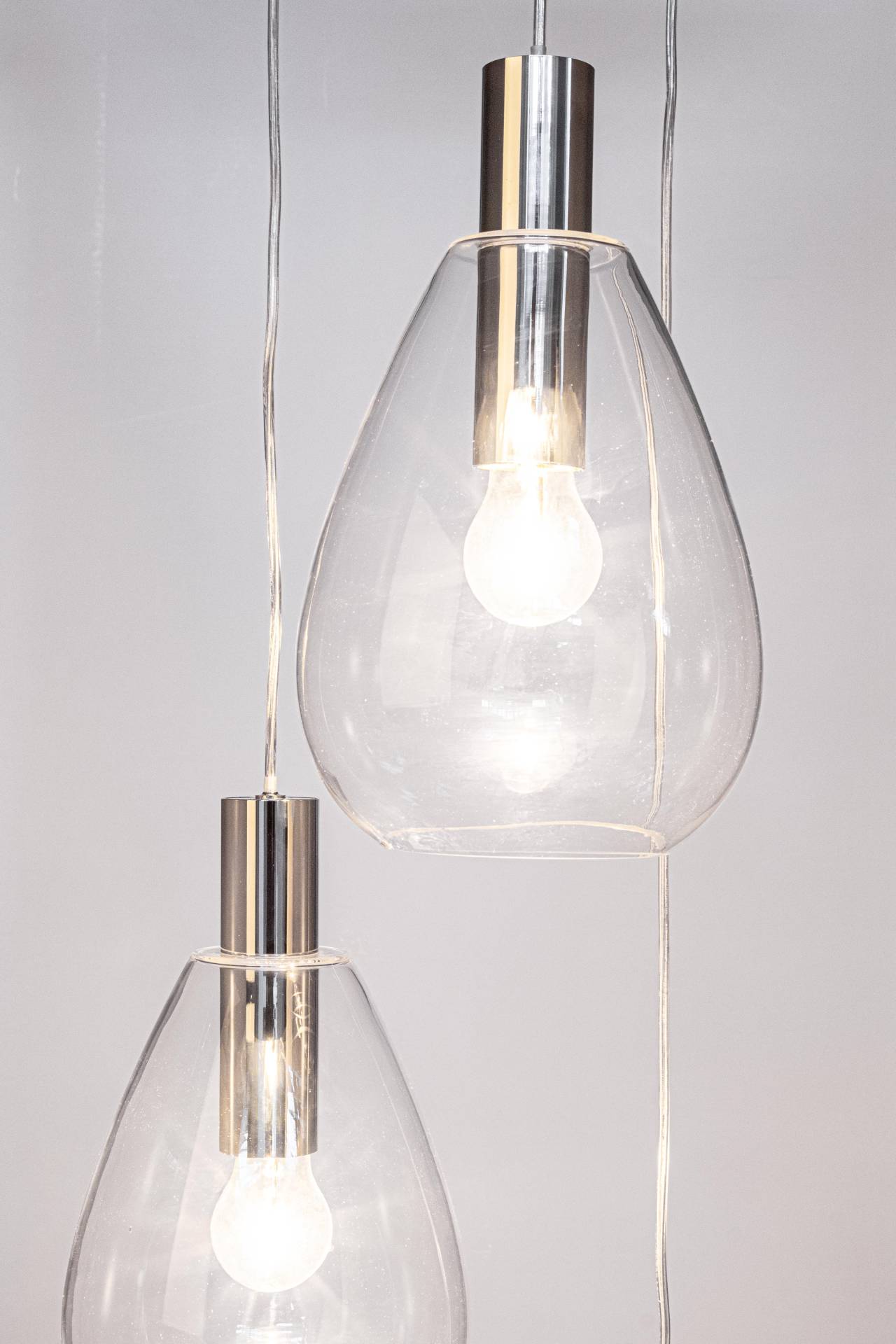 Die Hängeleuchte Glaring überzeugt mit ihrem modernen Design. Gefertigt wurde sie aus Metall, welches einen silberne Farbton besitzt. Die Lampenschirme sind aus Glas und sind klar. Die Lampe besitzt eine Höhe von 160 cm.