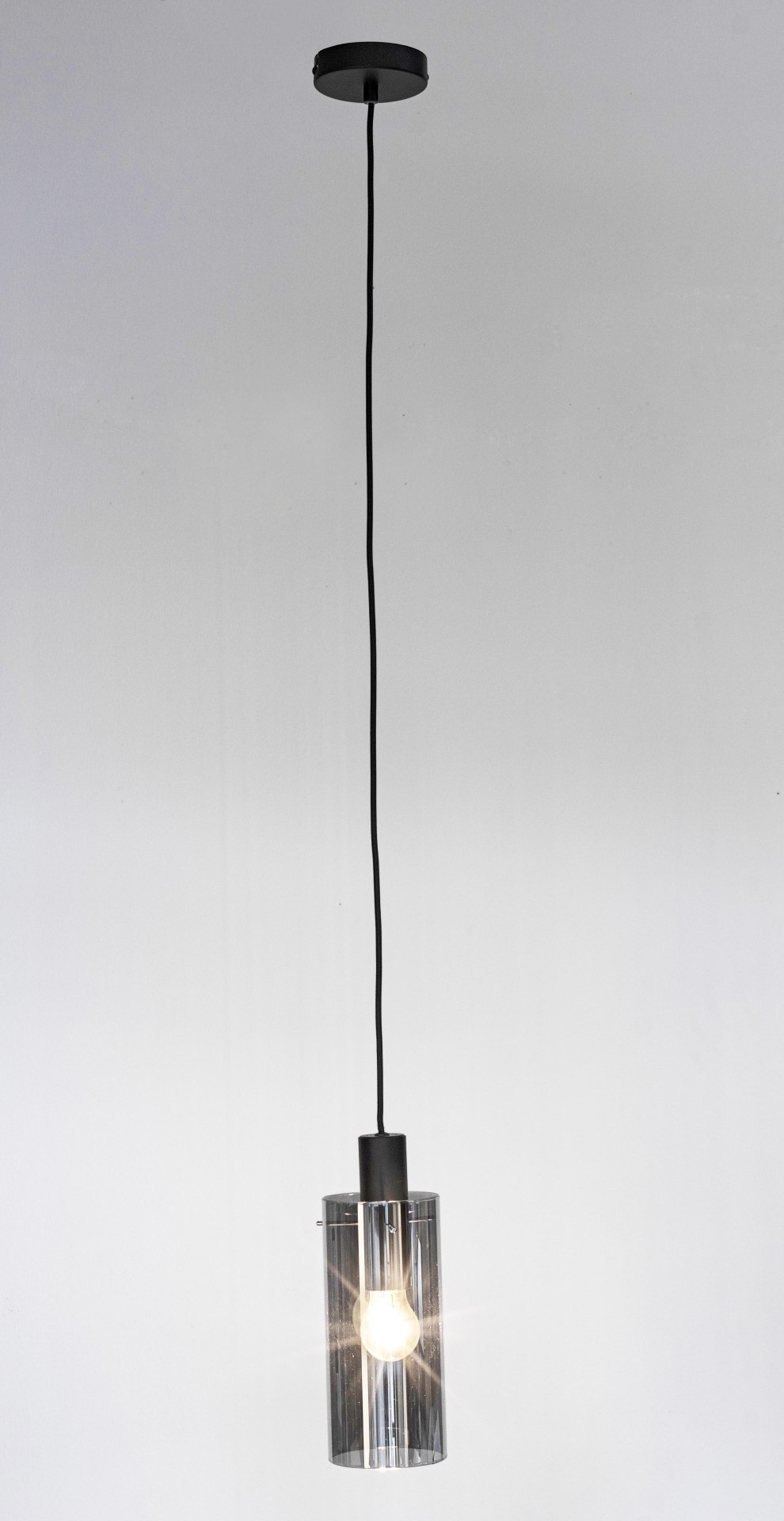 Die Hängeleuchte Aglow überzeugt mit ihrem modernen Design. Gefertigt wurde sie aus Metall, welches einen schwarzen Farbton besitzt. Der Lampenschirm ist aus Glas und ist abgedunkelt. Die Lampe besitzt eine Höhe von 130 cm.