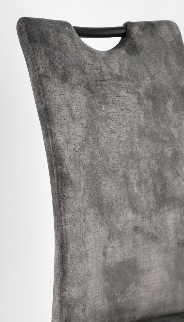 Der Esszimmerstuhl Kenneth überzeugt mit seinem modernen Stil. Gefertigt wurde er aus einem Samt Bezug, welcher einen grauen Farbton besitzt. Das Gestell ist aus Metall und hat eine schwarze Farbe.
