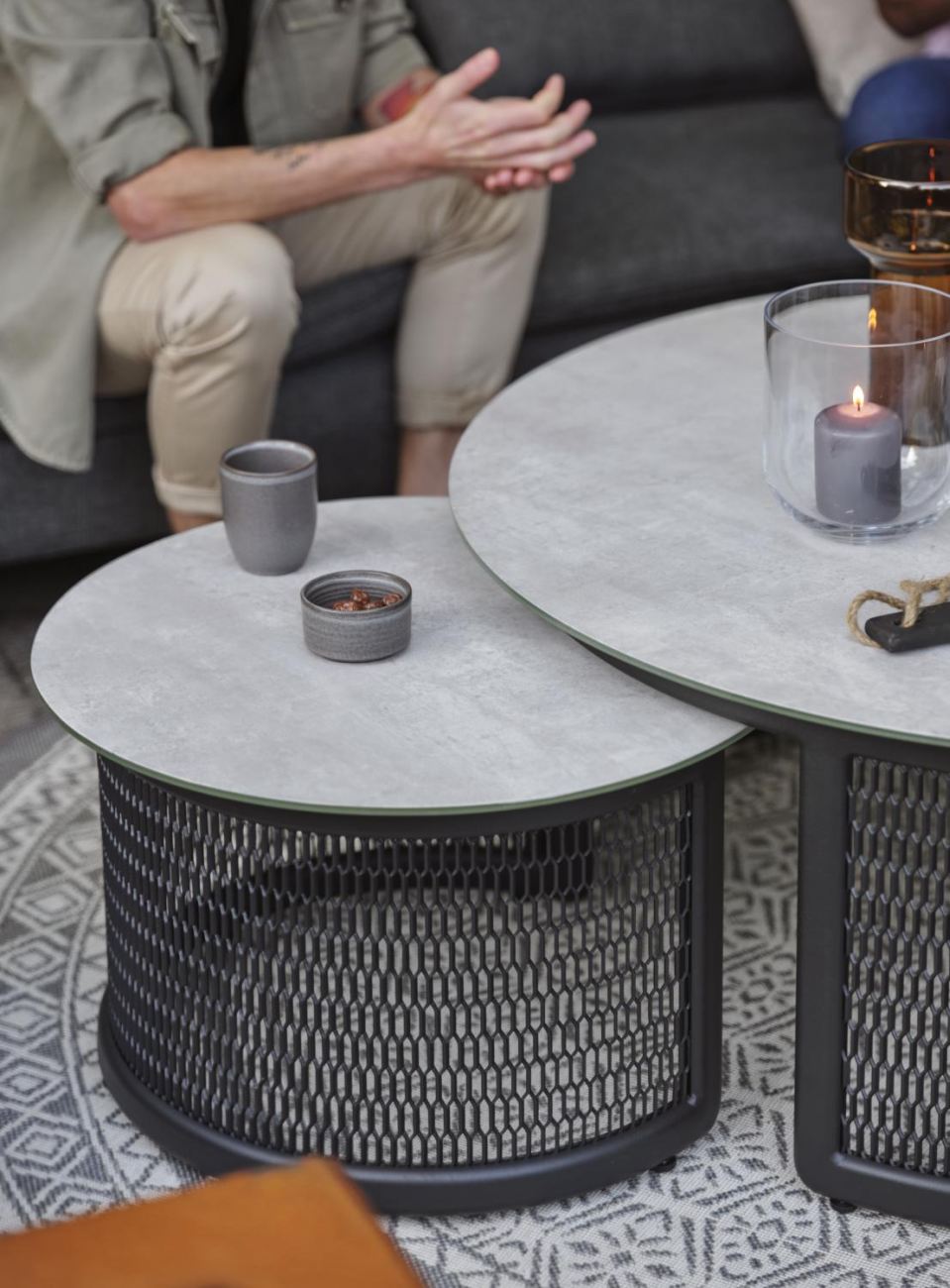Der Gartencouchtisch Virgo überzeugt mit seinem modernen Design. Gefertigt wurde die Tischplatte aus Granit, welche einen hellgrauen Farbton besitzt. Das Gestell ist auch aus Metall und hat eine schwarze Farbe. Der Tisch besitzt einen Durchmesser von 60 c