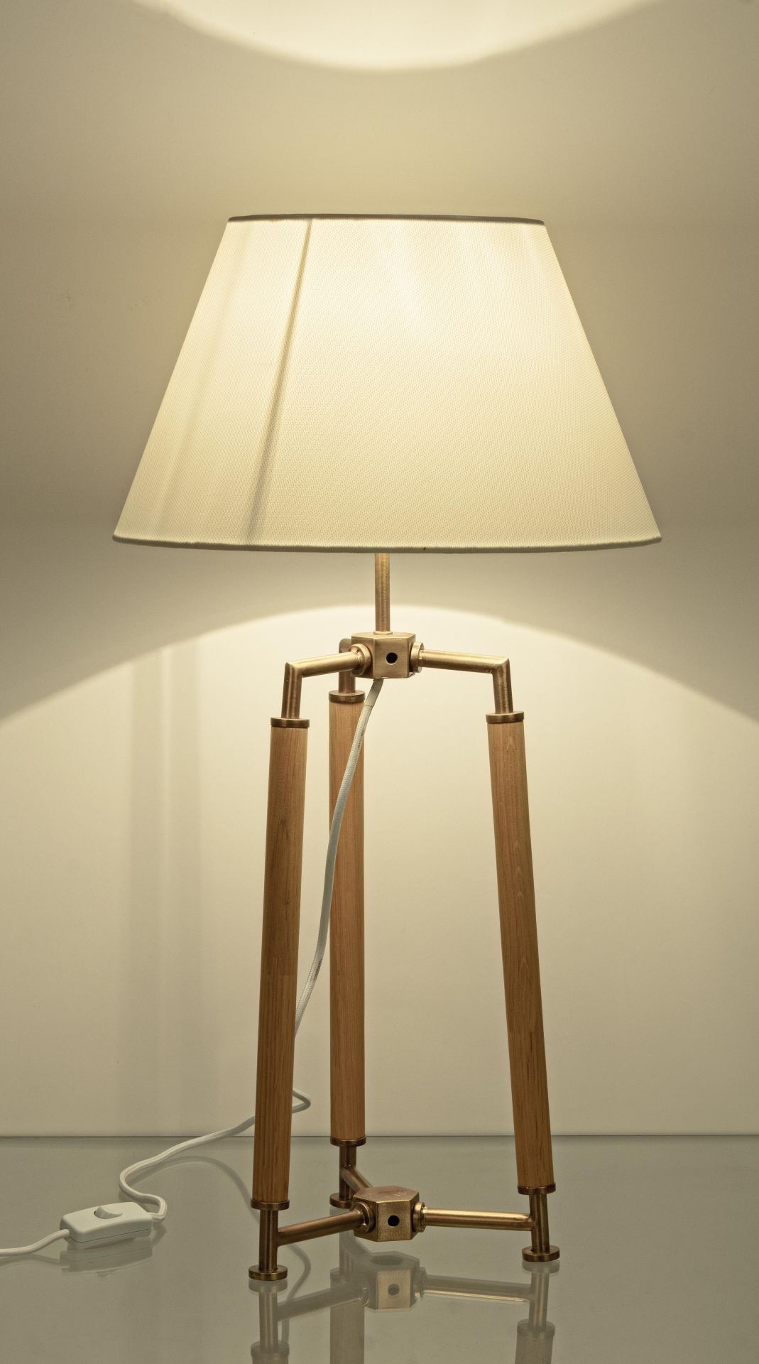 Die Tischleuchte Ellinor überzeugt mit ihrem klassischen Design. Gefertigt wurde sie aus Metall, welches einen Messing Farbton besitzt. Der Lampenschirm ist aus Baumwolle und hat eine weiße Farbe. Die Lampe besitzt eine Höhe von 65,5 cm.
