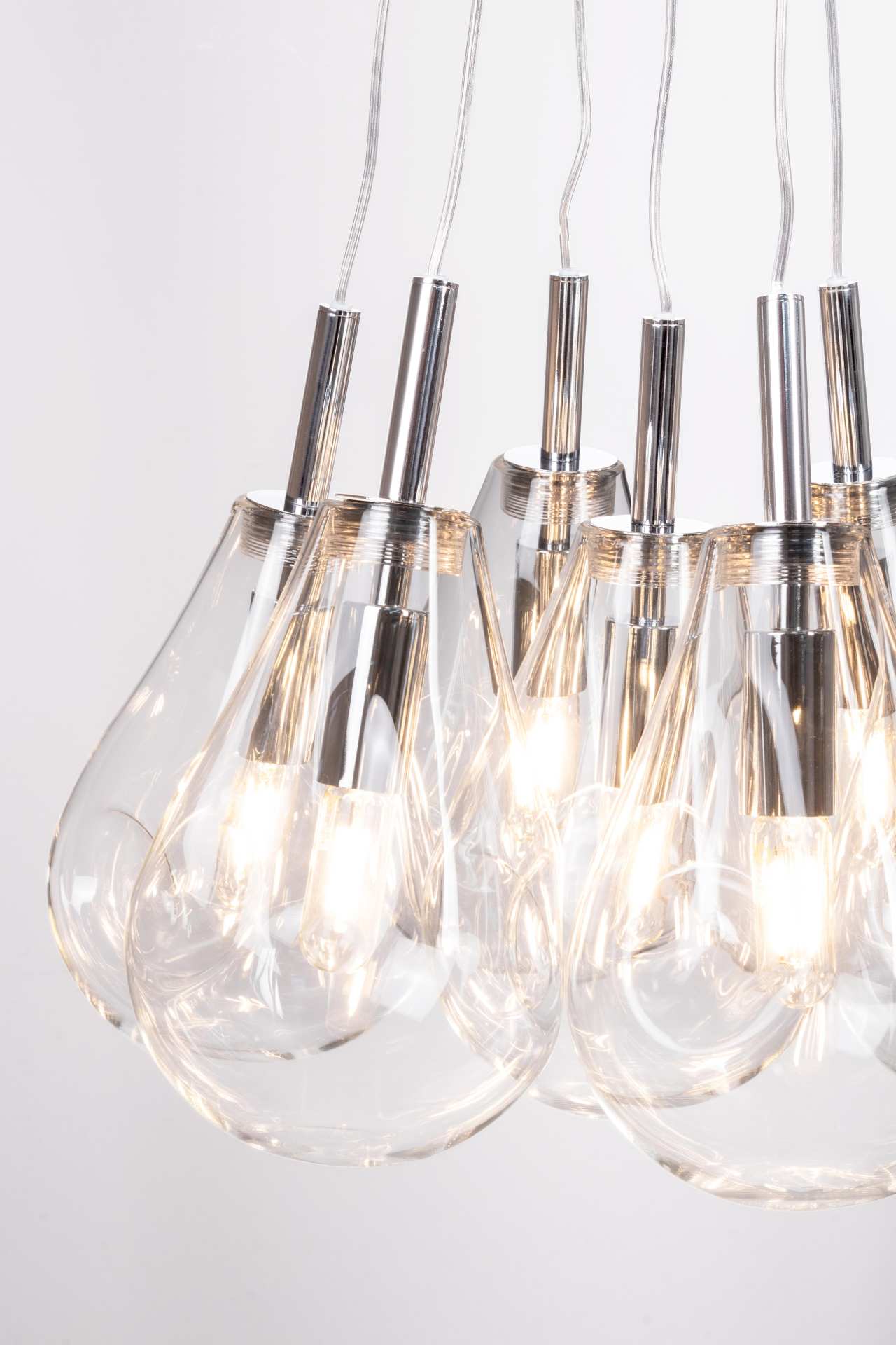 Die Hängeleuchte Refelct überzeugt mit ihrem modernen Design. Gefertigt wurde sie aus Metall, welches einen silberne Farbton besitzt. Die Lampenschirme sind aus Glas und sind klar. Die Lampe besitzt eine Höhe von 120 cm.