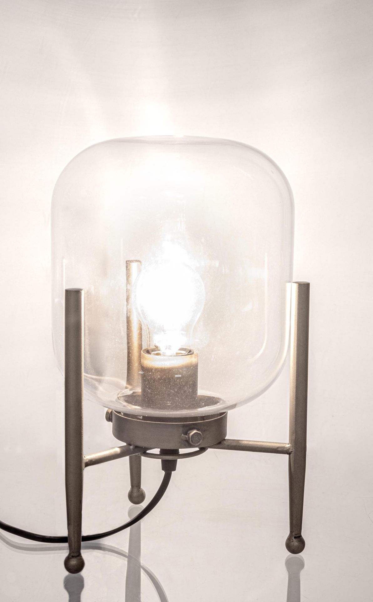 Die Tischleuchte Queer überzeugt mit ihrem klassischen Design. Gefertigt wurde sie aus Metall, welches einen Messing Farbton besitzt. Der Lampenschirm ist aus Glas.  Die Lampe besitzt eine Höhe von 30,5 cm.