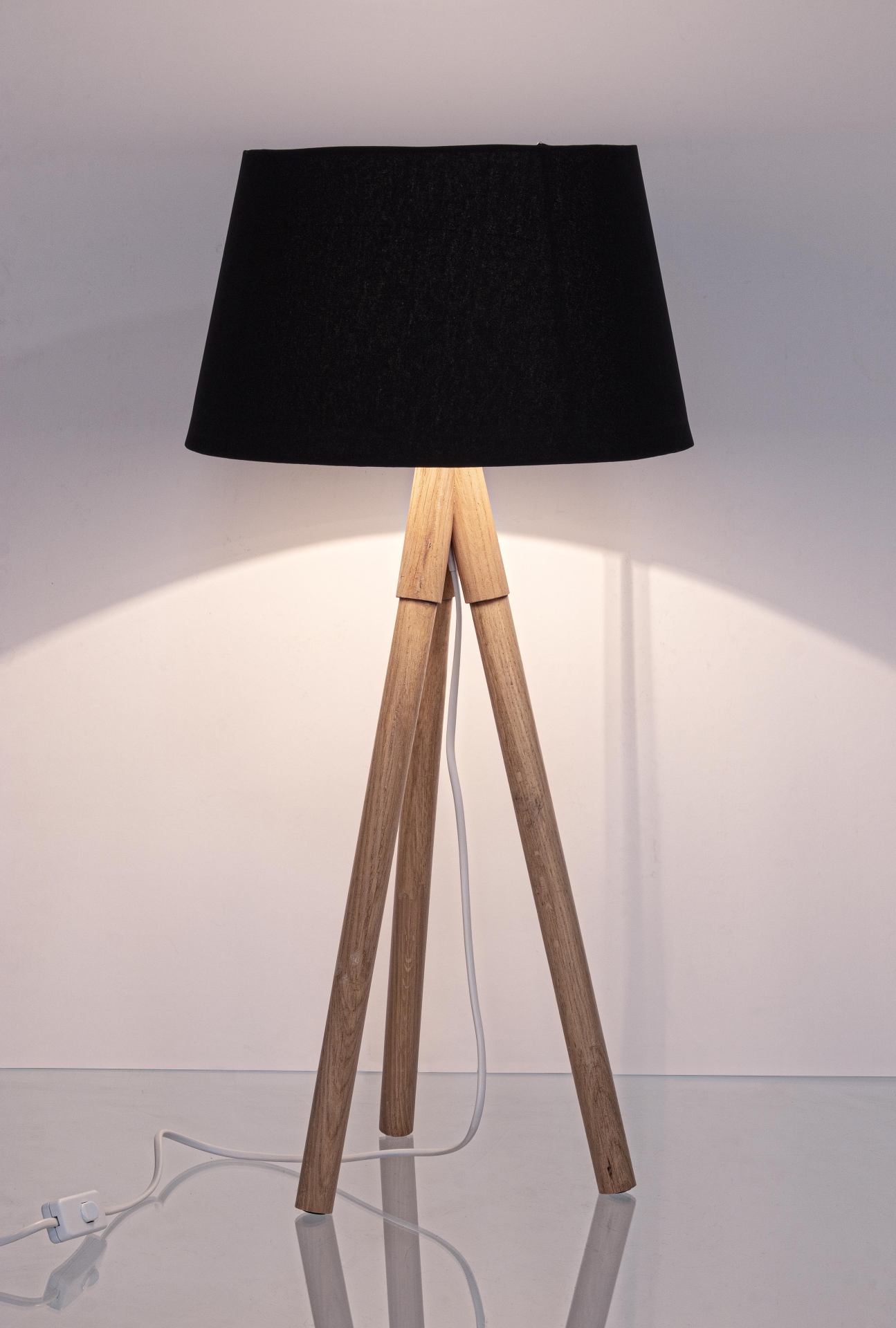Die Tischleuchte Wallas überzeugt mit ihrem klassischen Design. Gefertigt wurde sie aus Tannenholz, welches einen schwarzen Farbton besitzt. Der Lampenschirm ist aus Terital und hat eine weiße Farbe. Die Lampe besitzt eine Höhe von 69 cm.