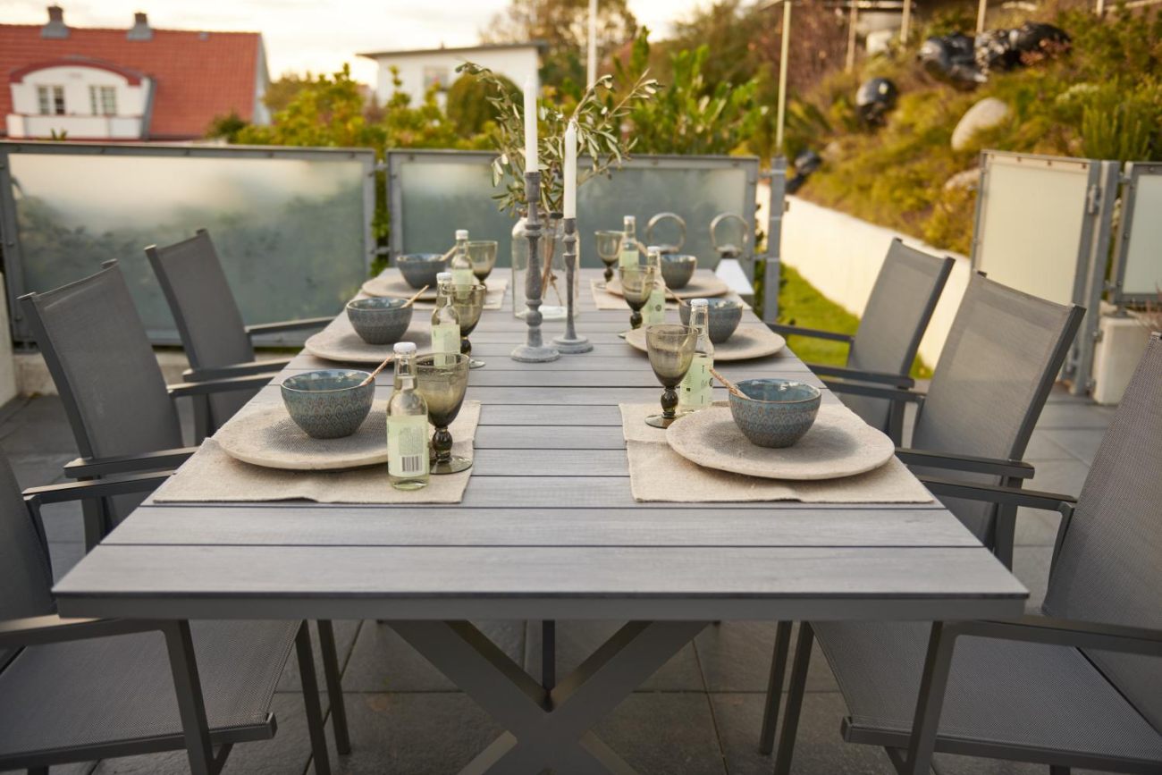 Der Gartenesstisch Hillmond überzeugt mit seinem modernen Design. Gefertigt wurde die Tischplatte aus Holz und besitzt einen grauen Farbton. Das Gestell ist auch aus Metall und hat eine schwarze Farbe. Der Tisch besitzt eine Länger von 166 cm welche bis a