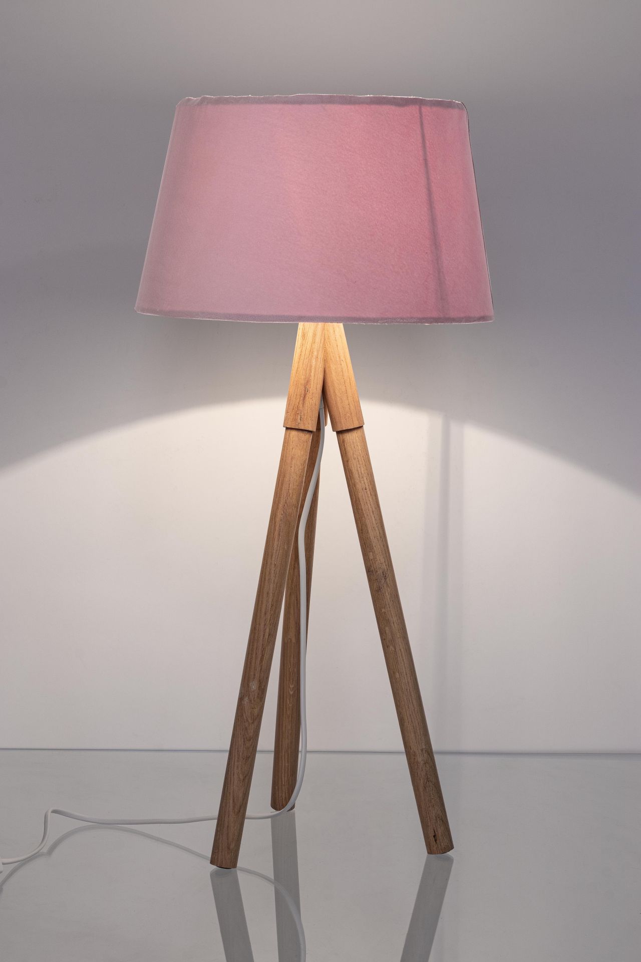 Die Tischleuchte Wallas überzeugt mit ihrem klassischen Design. Gefertigt wurde sie aus Tannenholz, welches einen natürlichen Farbton besitzt. Der Lampenschirm ist aus Samt und hat eine rosa Farbe. Die Lampe besitzt eine Höhe von 69 cm.