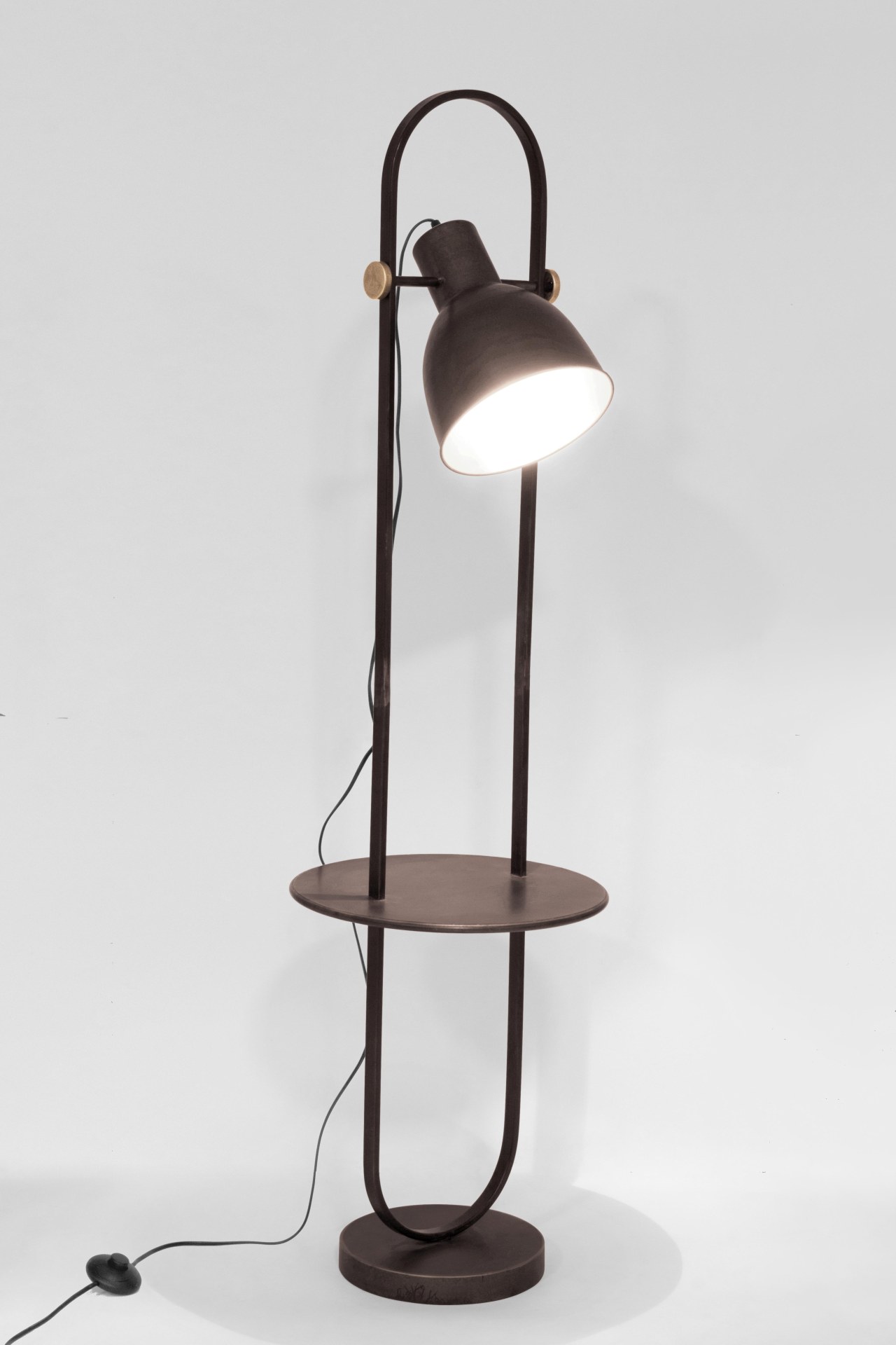 Die Stehleuchte ODD überzeugt mit ihrem klassischen Design. Gefertigt wurde sie aus Metall, welches einen schwarzen Farbton besitzt. Die Lampe besitzt eine Holzplatte in einer natürlichen Farbe. Die Lampe besitzt eine Höhe von 140 cm.