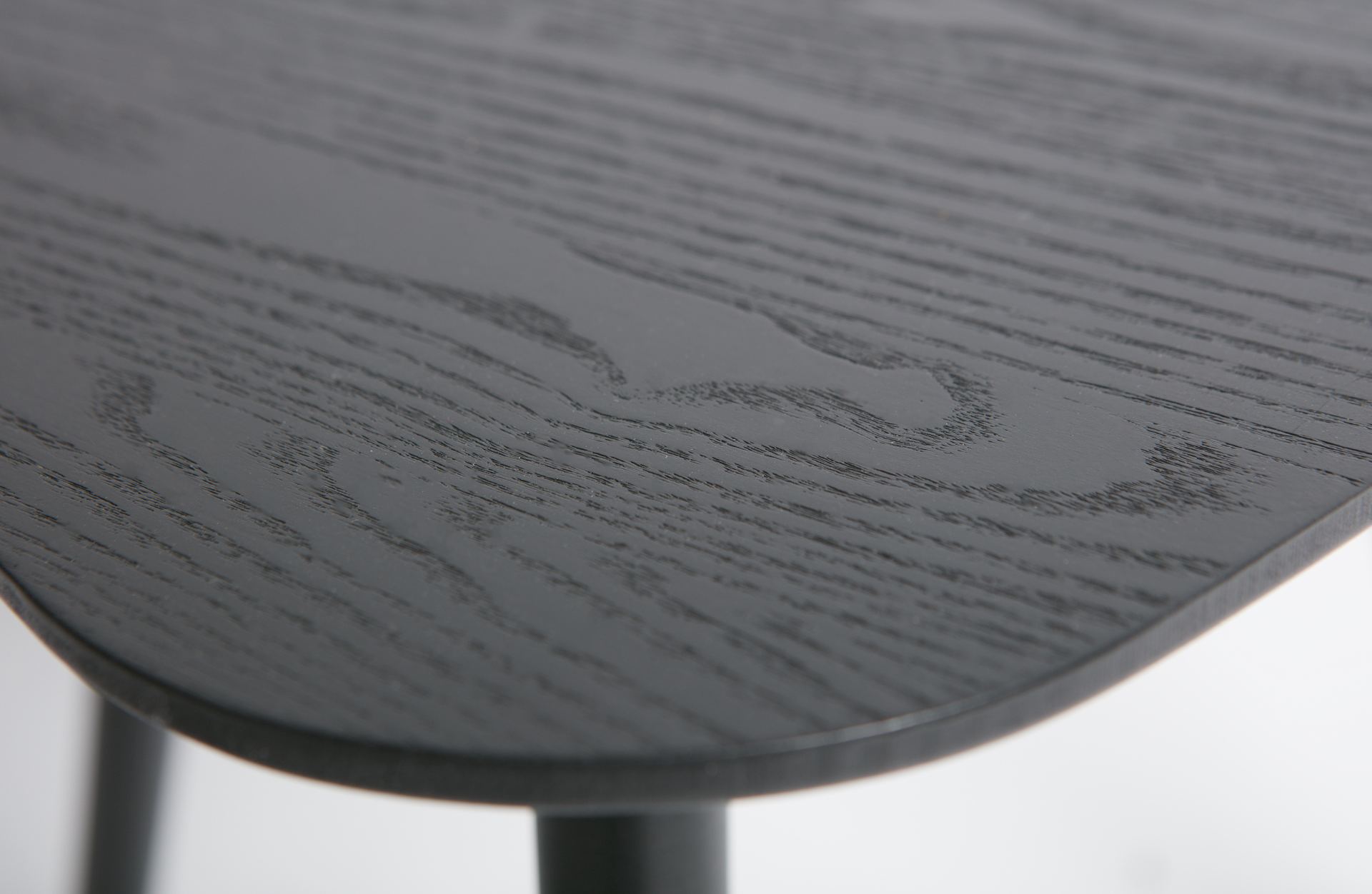 Der Beistelltisch Nila besitzt eine dreieckige Form. Die Tischplatte wurde aus Eschenholz gefertigt und die Beine aus Pinienholz. Der Beistelltisch hat eine Schwarze Farbe.