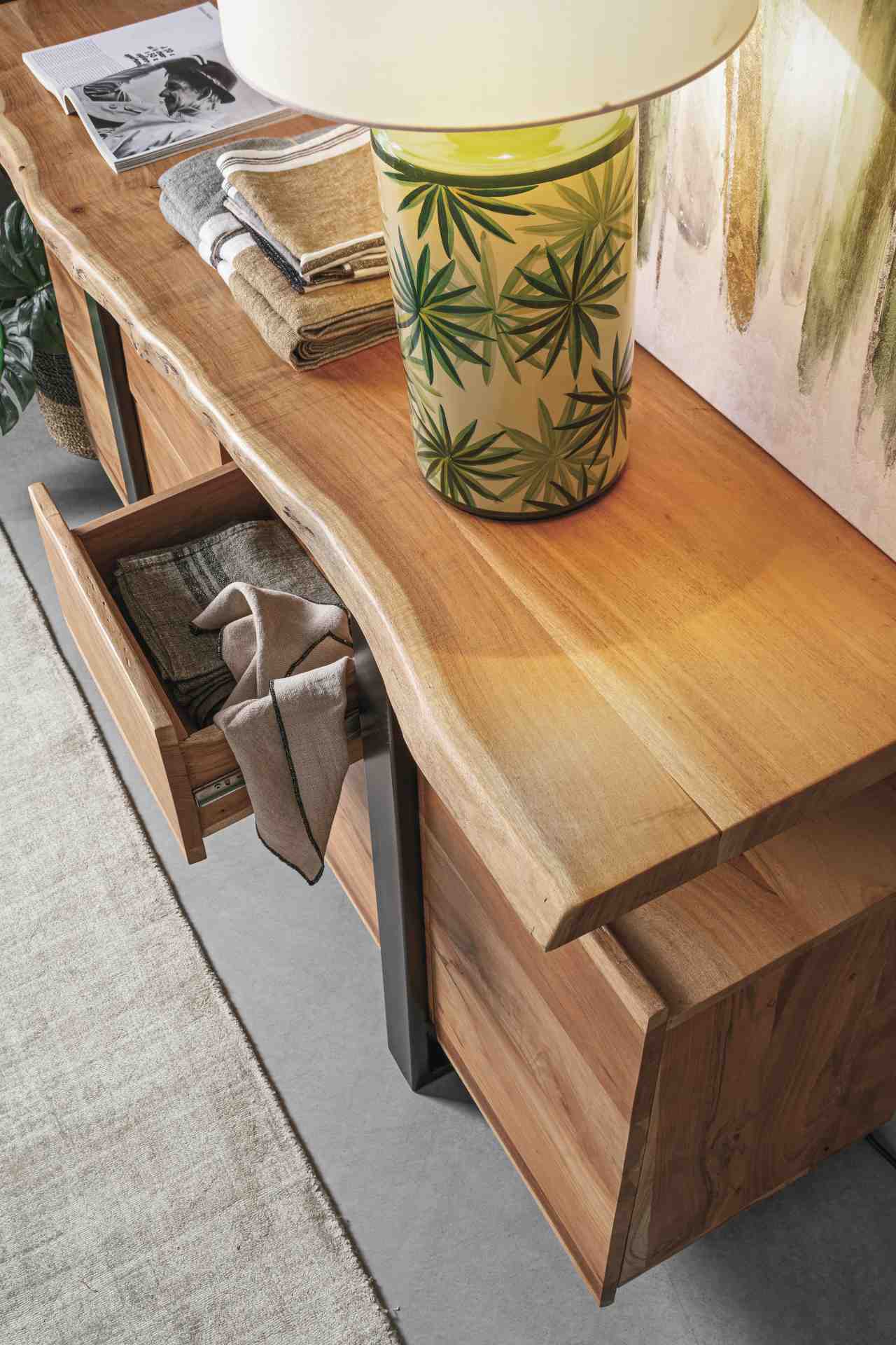 Das Sideboard Aron überzeugt mit seinem modernen Design. Gefertigt wurde es aus Akazien-Holz, welches einen natürlichen Farbton besitzt. Das Gestell ist aus Metall und hat eine schwarze Farbe. Das Sideboard verfügt über vier Türen und zwei Schubladen. Die