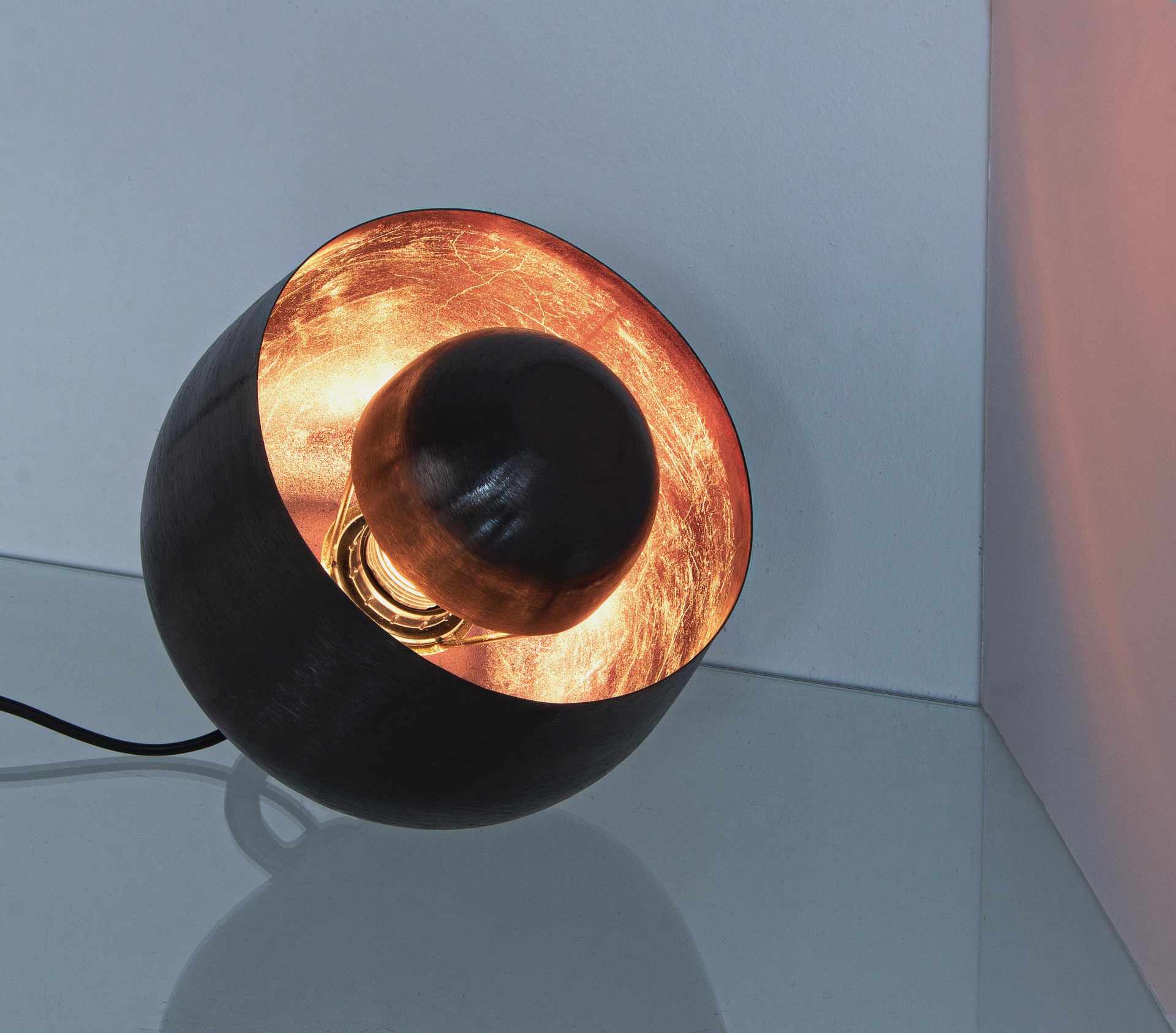 Die Tischleuchte Ishan überzeugt mit ihrem modernen Design. Gefertigt wurde sie aus Metall, welches einen schwarzen Farbton besitzt. Die Lampe hat eine Lichtquelle. Die Lampe besitzt eine Höhe von 22 cm.