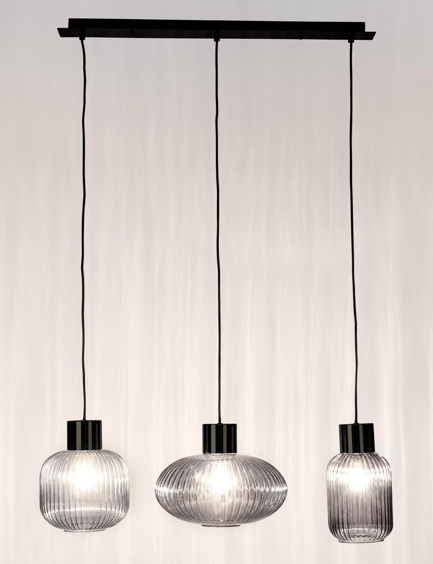 Die Hängeleuchte Showy überzeugt mit ihrem modernen Design. Gefertigt wurde sie aus Metall, welches einen schwarzen Farbton besitzt. Die Lampenschirme sind aus Glas und sind abgedunkelt. Die Lampe besitzt eine Höhe von 120 cm.