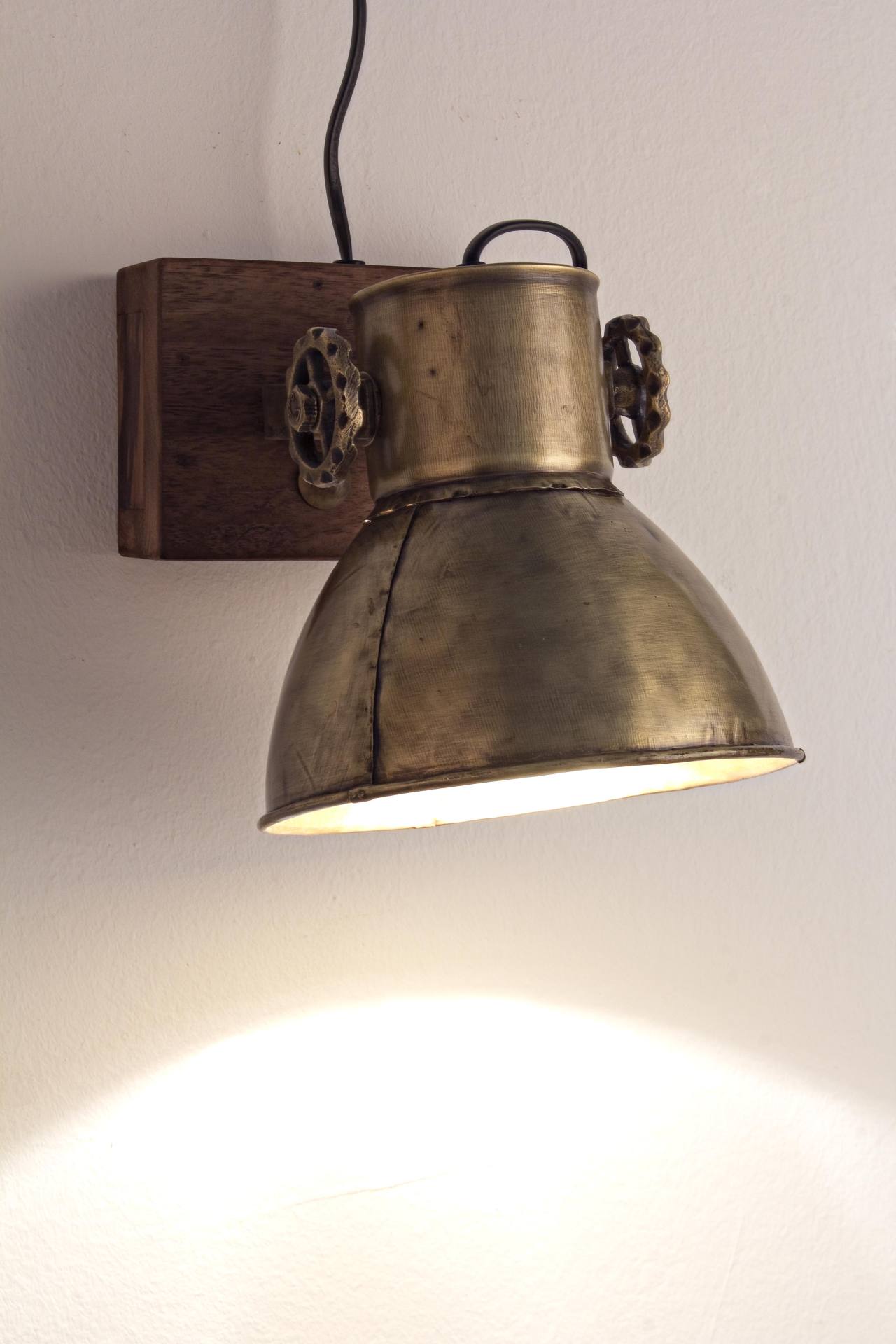 Die Wandleuchte Appllique überzeugt mit ihrem klassischen Design. Gefertigt wurde sie aus Mangoholz, welches einen natürlichen Farbton besitzt. Der Lampenschirm ist aus Metall und hat eine goldene Farbe. Die Lampe besitzt eine Höhe von 27 cm.